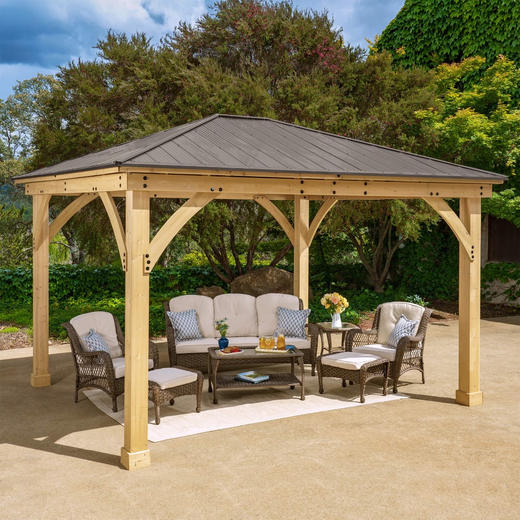 Wooden gazebo with patio furniture installed in a backyard